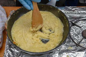 Preparation of traditional melted cheese in a pot