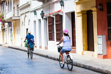 Family riding on rental bikes around the walled city in Cartagena de Indias - obrazy, fototapety, plakaty