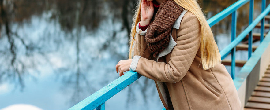 girl in a brown jacket near the river and a brown scarf, snod. autumn, knitted things, handmade,