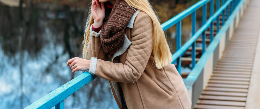 girl in a brown jacket near the river and a brown scarf, snod. autumn, knitted things, handmade,