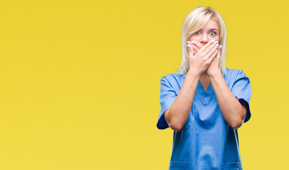 Young beautiful blonde nurse doctor woman over isolated background shocked covering mouth with hands for mistake. Secret concept.