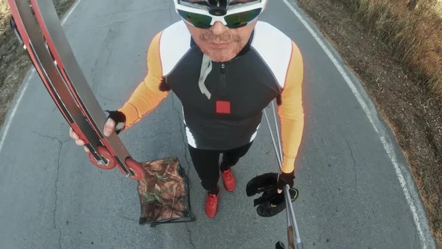 Training an athlete on the roller skaters. Biathlon ride on the roller skis with ski poles, in the helmet. Autumn workout. Roller sport. Adult man riding on skates. Pov view action cam. Handheld