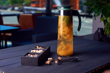 tea with sea buckthorn in glass teapot, selective focus with sugar