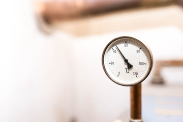 Tube pressure gauge measuring the water temperature on central home heating system in Celsius.
