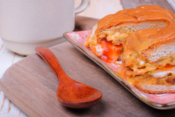 John bread and spoon   with a cup off coffee on wooden cutting board
