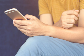 Young male casual wear using on cell phone during rest on sofa. sitting in watching message on mobile phone during break relax.