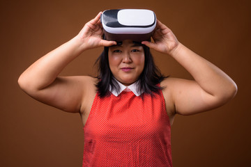 Fototapeta na wymiar Portrait of Asian woman holding virtual reality VR glasses