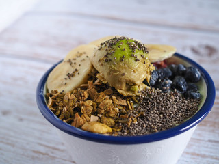 Homemade healthy bowl. Yogurt , Granola , Banana , Avocado , chia seeds, blueberries in white and blue bowl. Clean food concept. Healthy breakfast.