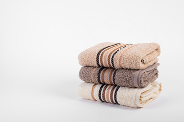 A stack of bath towels on white background, isolated, a lot of empty space
