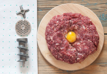 Raw minced meat and other ingredients on cutting board