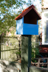 Blue bird house on pole fence outside terrace house