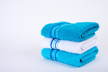 A stack of bath towels on white background, isolated, a lot of empty space