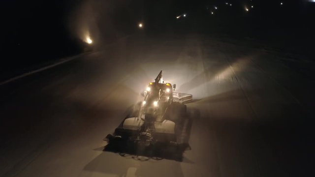 Aerial - Night shot of snow cat grooming the ski slope