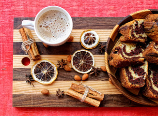 a cup of coffee and a marble cake in the wooden plate on the striped cutting Board with dry lemon,cinnamon 