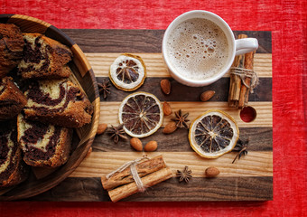 Fototapeta na wymiar a cup of coffee and a marble cake in the wooden plate on the striped cutting Board with dry lemon,cinnamon 