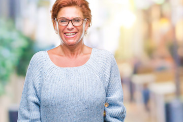 Atrractive senior caucasian redhead woman wearing glasses over isolated background with a happy and cool smile on face. Lucky person.