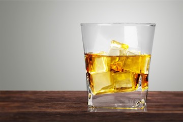 Glass of whiskey and Ice on wooden
