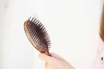 Women's hand hair brush with hair loss,   dandruff and health problems.
