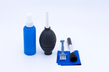 Cleaning kit for lenses and dslr camera sensors, blower, brush and microfiber cloth isolated on white background.