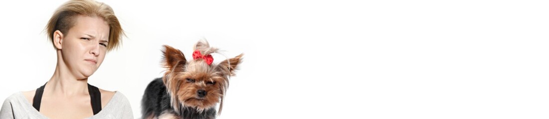 The funny woman and her dog with suspicious mistrustful look over white background. Yorkshire...