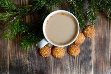 Obraz na płótnie Canvas Coffee with milk, hot chocolate or cocoa with cinnamon stick in a Cup and fir branches. Winter hot drink for cold weather. New year and Christmas concept