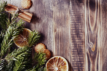 Christmas and new year background frame or postcard Christmas composition with fir branches dried oranges cookies cinnamon sticks and a scarf on a wooden background