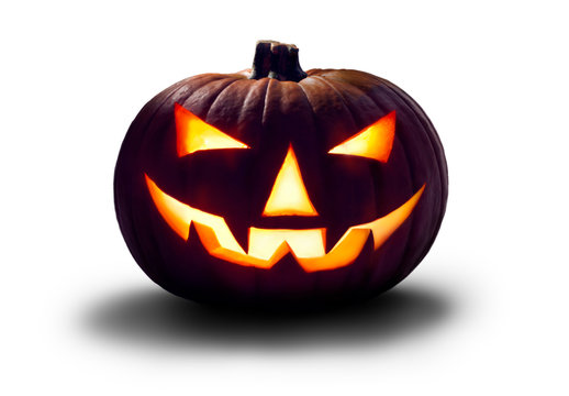 A carved halloween pumpkin with evil glowing eyes isolated on white to use on dark images.