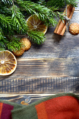 Christmas and new year background frame or card Christmas composition with fir branches dried oranges cookies cinnamon sticks and a scarf on a wooden background