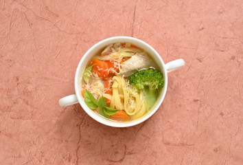 Chicken soup with vegetables and noodles, top view