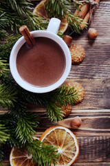 Hot chocolate or cocoa with cinnamon stick in a cup and fir branches. Winter hot drink for cold weather. New year and Christmas concept Top view