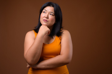 Obraz premium Beautiful overweight Asian woman thinking and looking up