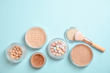 Flat lay composition with various makeup face powders on color background. Space for text