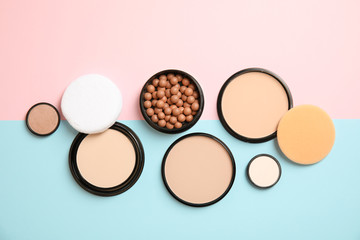 Flat lay composition with various makeup face powders on color background