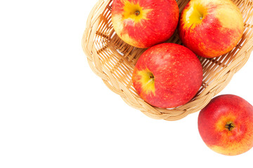 Apples in wicker basket on isolated background.