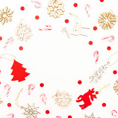 Christmas frame with wooden decoration, snowflakes and candy canes on white background. Flat lay, top view. New Year concept.