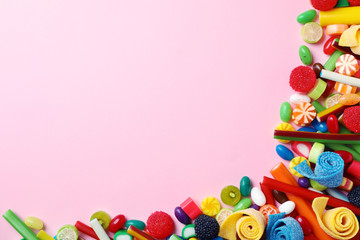 Flat lay composition with delicious colorful candies and space for text on color background