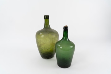 Zwei große alte Flaschen in zweierlei grün mit altem Dreck 