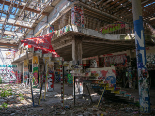 Stairs leading up to another floor in an old abandoned building or factory, completely destroyed and vandalized, painted with colourful graffiti street art