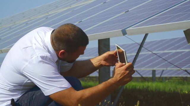 Male taking picture of the back side of solar panel