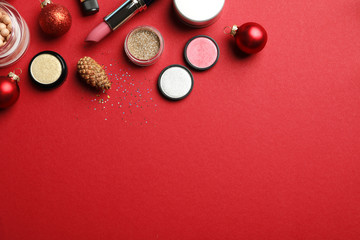 Flat lay composition with makeup products and Christmas decor on color background. Space for text