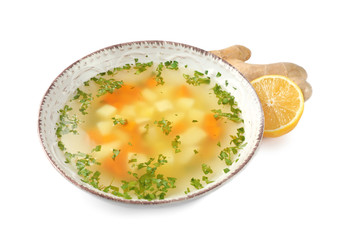 Bowl of fresh homemade soup to cure flu, lemon and ginger on white background