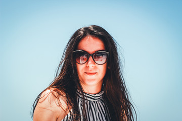 The girl in a black and white dress in a geometric strip. Dissolved hair. Journey on boat on the red sea in Egypt. Brunette on the trip. Fashion photo shoot