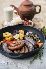 Grilled different meat sausages with vegetables and spices