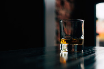 glass of whiskey on black background