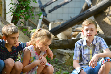 Children are near the ruined house, the concept of natural disaster, fire, and devastation.