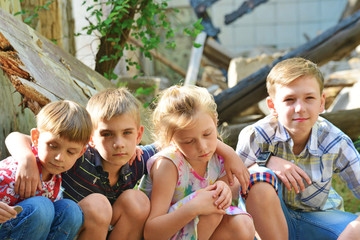 Children are near the ruined house, the concept of natural disaster, fire, and devastation.