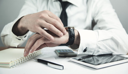 Businessman adjusting his wristwatch. Business concept