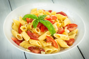 Piatto di penne con pomodoro fresco, olio di oliva, aglio, origano e basilico fresco, Mediterranean...