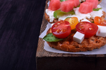 Assortment of bruschettas against the dark background. Copy space
