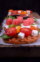 Assortment of bruschettas with figs, watermelon, cherry tomatoes, cheese and honey